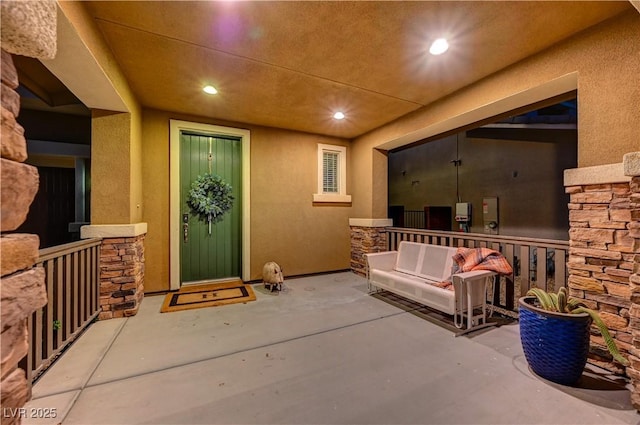 view of exterior entry with stone siding and stucco siding