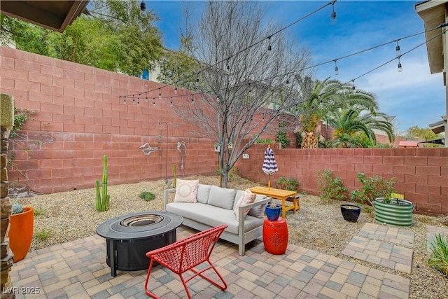 view of patio featuring a fenced backyard and an outdoor living space with a fire pit