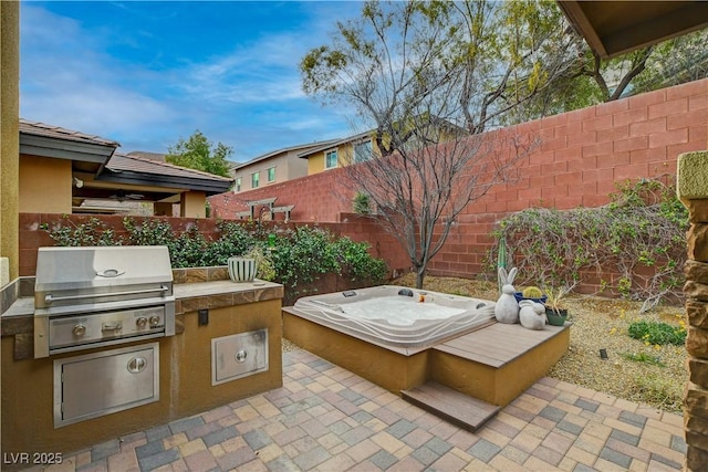 view of patio / terrace with a fenced backyard, exterior kitchen, and area for grilling