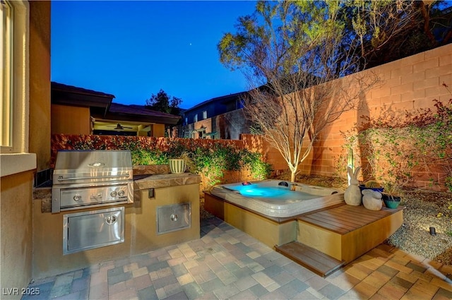 view of patio / terrace featuring a fenced backyard, an outdoor hot tub, and area for grilling