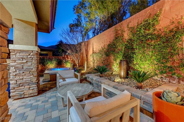 view of patio featuring a hot tub and a fenced backyard