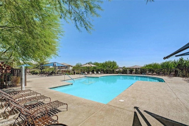 pool with a patio area and fence