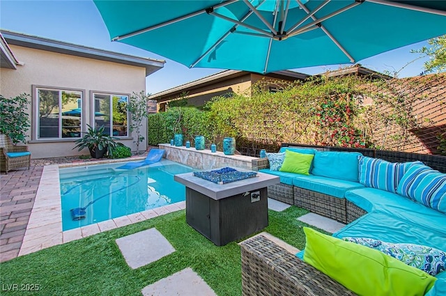 view of pool with a patio, an outdoor living space with a fire pit, and a fenced in pool