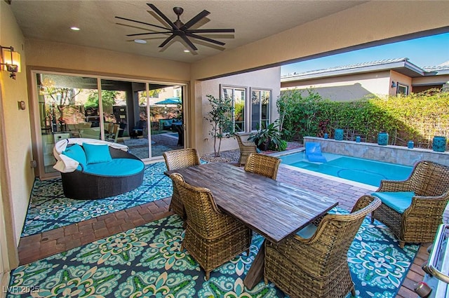 view of patio / terrace with an outdoor pool and a ceiling fan