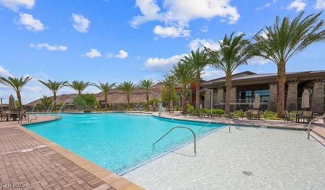 pool with a patio area and fence