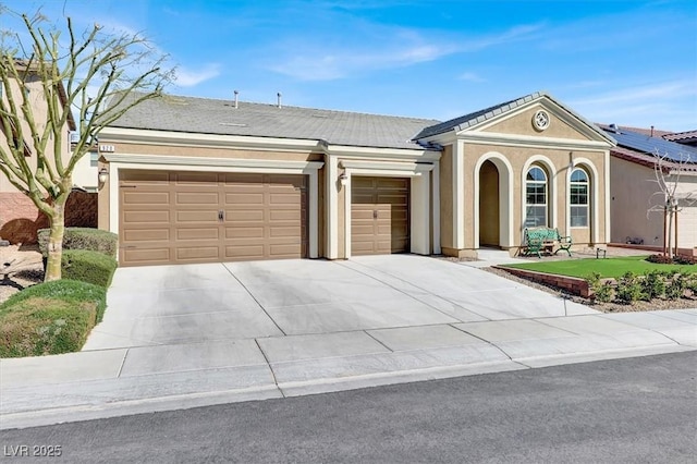 view of front of property featuring a garage, concrete driveway, and stucco siding