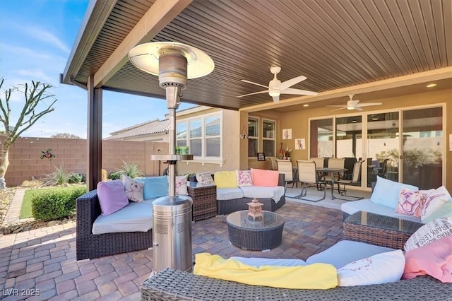 view of patio / terrace with a ceiling fan, outdoor dining area, fence, and an outdoor hangout area