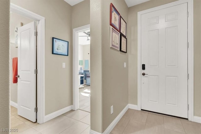 foyer with light tile patterned floors and baseboards