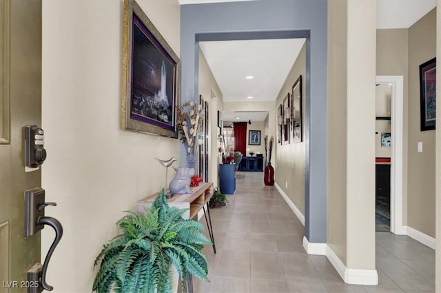 corridor with tile patterned flooring and baseboards