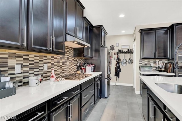 kitchen with under cabinet range hood, stainless steel appliances, light tile patterned floors, and light countertops