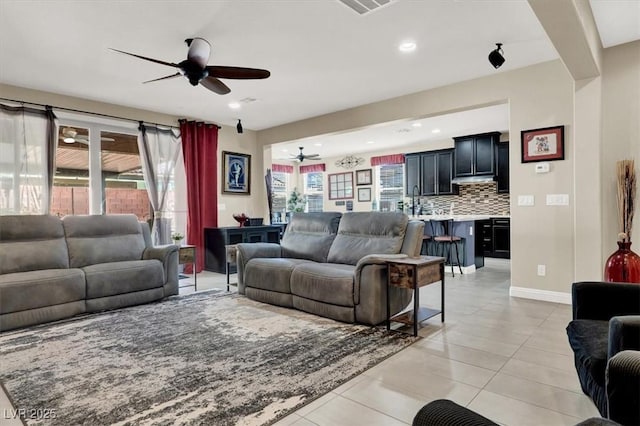 living area with visible vents, baseboards, a ceiling fan, light tile patterned flooring, and recessed lighting