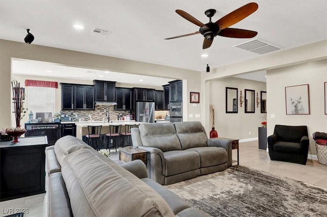 living area with light tile patterned floors, visible vents, and recessed lighting