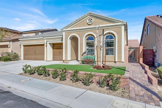 view of front of house with a garage, a tile roof, concrete driveway, a gate, and stucco siding