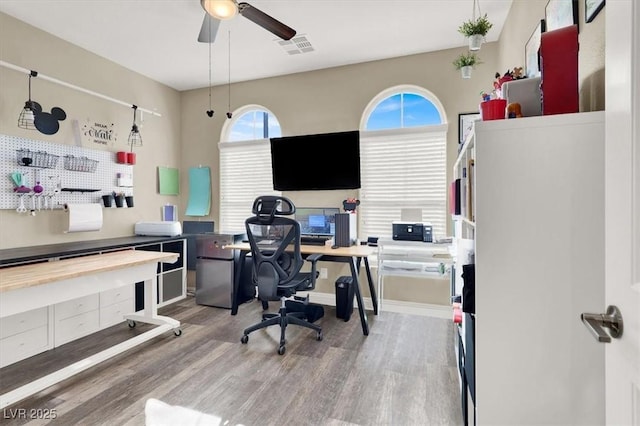 office space with visible vents, ceiling fan, and wood finished floors