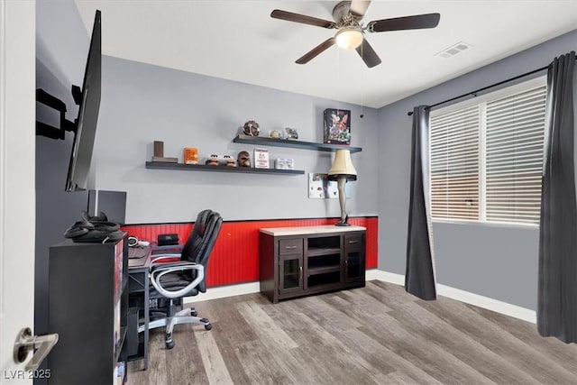 office area with ceiling fan, visible vents, baseboards, and wood finished floors