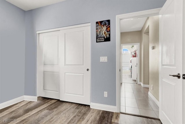 unfurnished bedroom with baseboards, a closet, and wood finished floors