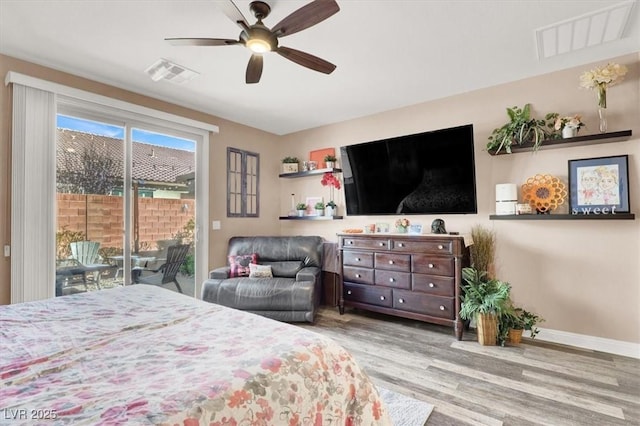 bedroom with access to exterior, visible vents, baseboards, and wood finished floors