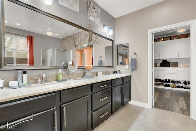 full bath featuring tile patterned flooring, a sink, a ceiling fan, baseboards, and double vanity