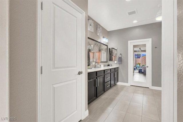 full bath with tile patterned flooring, a sink, visible vents, baseboards, and double vanity