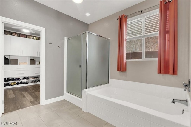 full bath featuring baseboards, a stall shower, a garden tub, and tile patterned floors