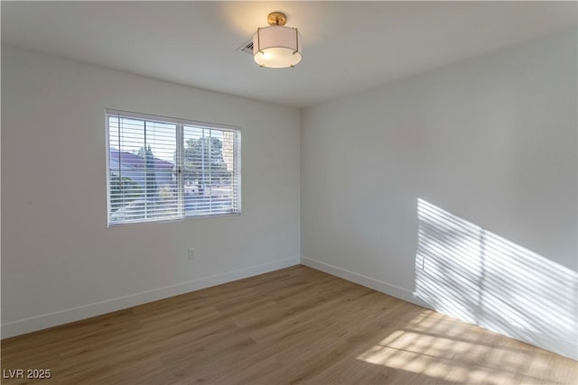 empty room featuring wood finished floors and baseboards