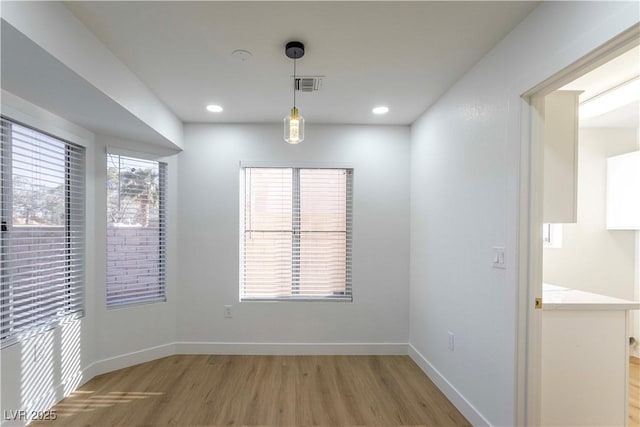 unfurnished dining area featuring light wood finished floors, baseboards, visible vents, and recessed lighting