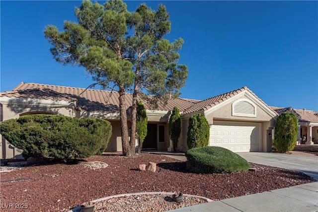 view of front of home with an attached garage, stucco siding, concrete driveway, and a tiled roof