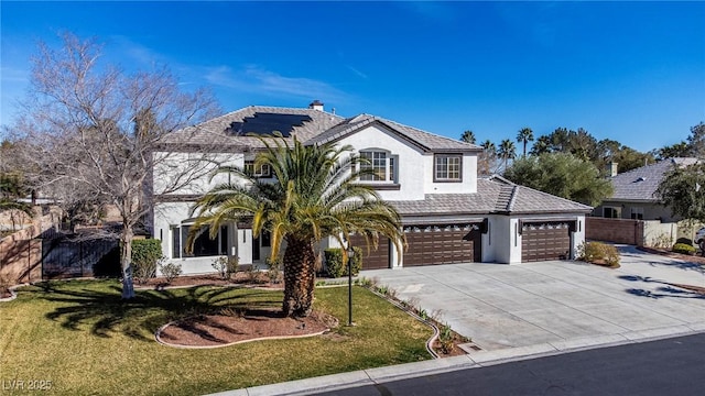 view of front of home with driveway, solar panels, fence, a front lawn, and stucco siding