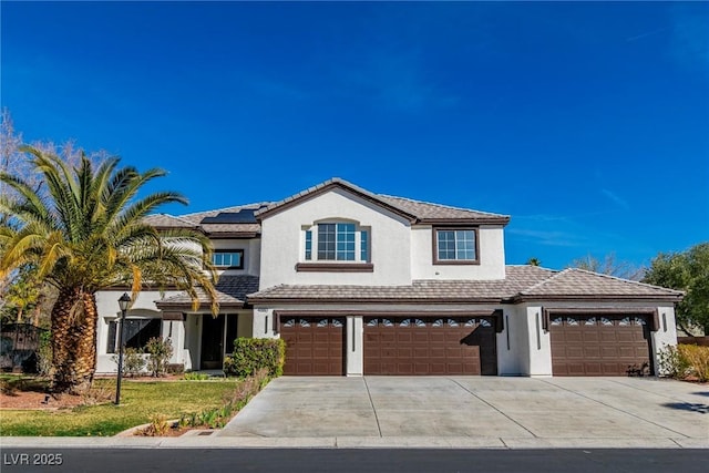 view of front of property with concrete driveway, solar panels, a tiled roof, an attached garage, and stucco siding