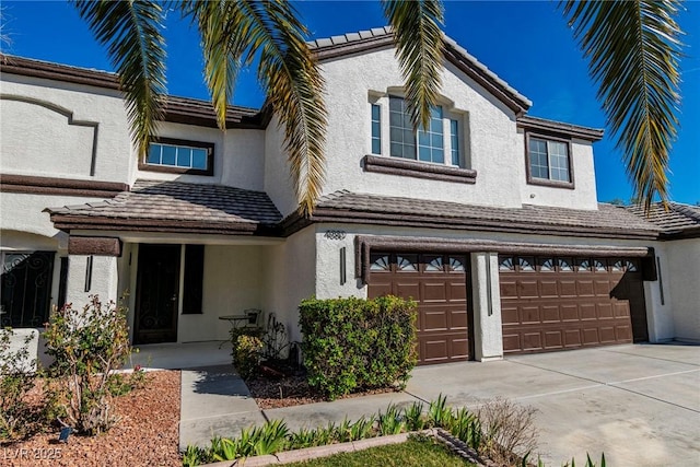 view of front of home featuring concrete driveway, an attached garage, and stucco siding