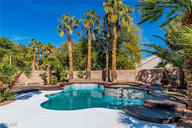 view of swimming pool featuring a pool with connected hot tub and a fenced backyard