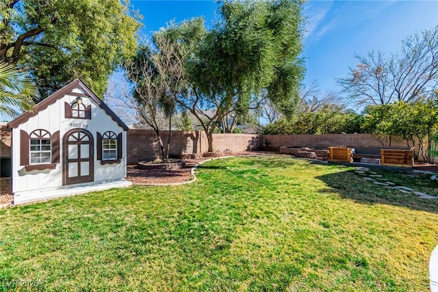 view of yard with an outdoor structure and a fenced backyard