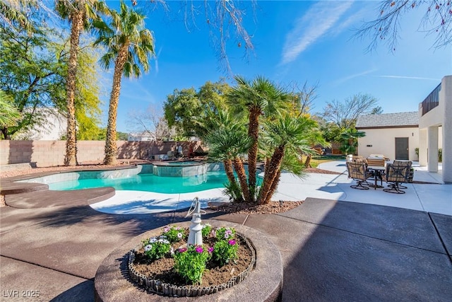 view of pool featuring a patio area, a pool with connected hot tub, and fence