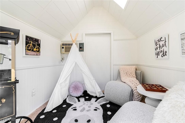 bedroom featuring a wainscoted wall, vaulted ceiling, and an AC wall unit