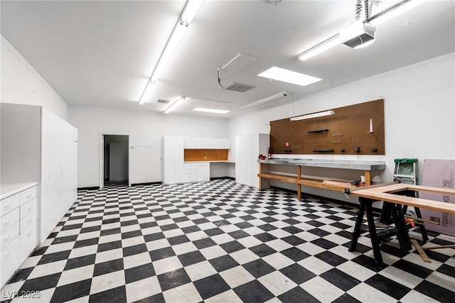 interior space featuring visible vents, a workshop area, and a garage door opener