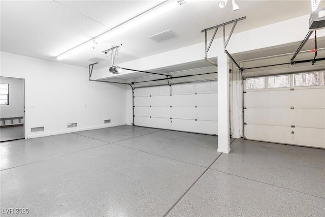 garage featuring baseboards, visible vents, and a garage door opener