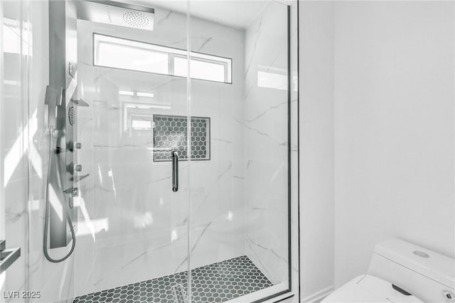 full bathroom featuring a marble finish shower and toilet