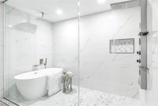 full bathroom featuring a freestanding tub and a marble finish shower