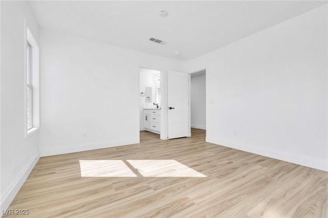 unfurnished bedroom with light wood finished floors, baseboards, and visible vents