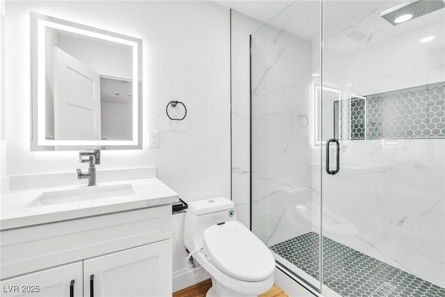 bathroom featuring a textured wall, vanity, a marble finish shower, and toilet