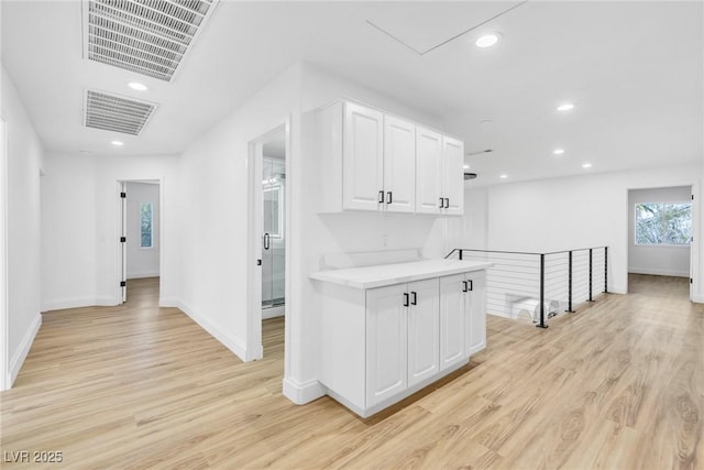 hall with light wood finished floors, visible vents, and recessed lighting