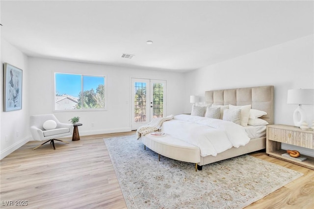 bedroom featuring light wood-style floors, french doors, visible vents, and baseboards