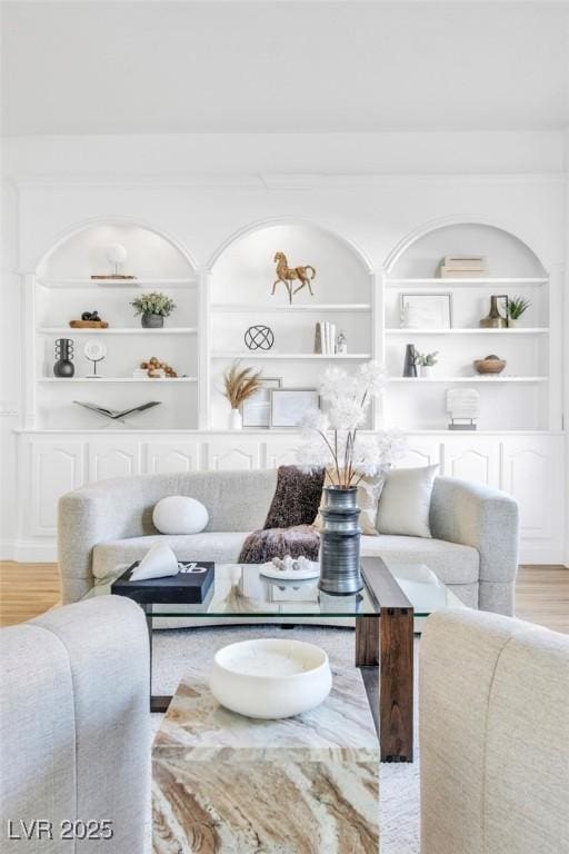 living room featuring built in features and wood finished floors