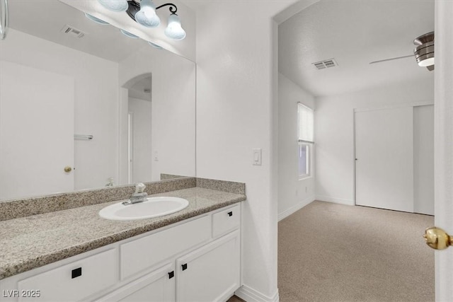 bathroom with baseboards, visible vents, a ceiling fan, and vanity