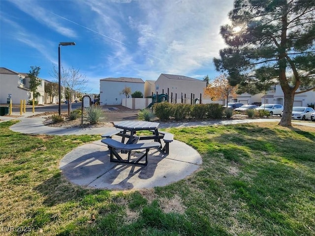 view of home's community featuring a residential view, a lawn, and a patio