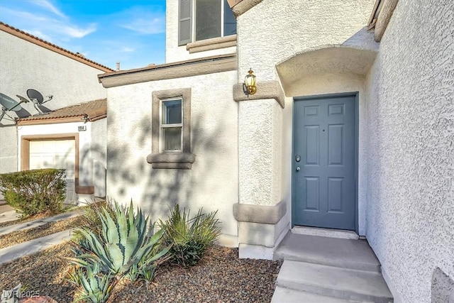 doorway to property featuring stucco siding