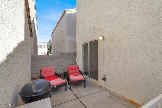 view of patio featuring a grill and fence