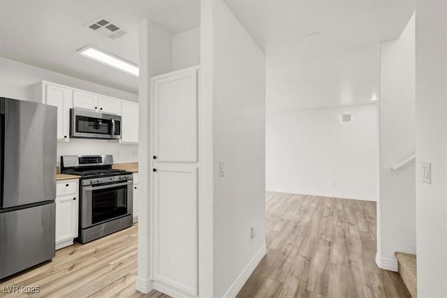 kitchen featuring light wood finished floors, visible vents, appliances with stainless steel finishes, and white cabinets