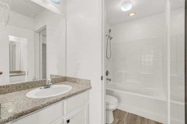 bathroom featuring shower / bathtub combination, vanity, wood finished floors, and toilet