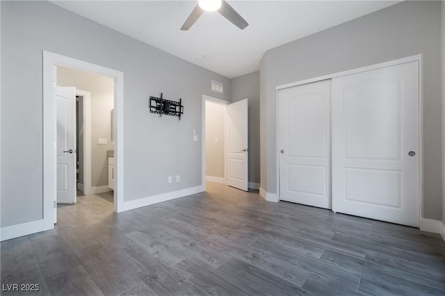 unfurnished bedroom featuring a closet, baseboards, and wood finished floors